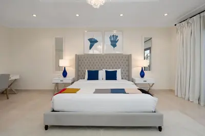 a bedroom with a large bed with blue pillows at Maison Privee - Exclusive Villa with Private Pool, Garden & Beach in Dubai