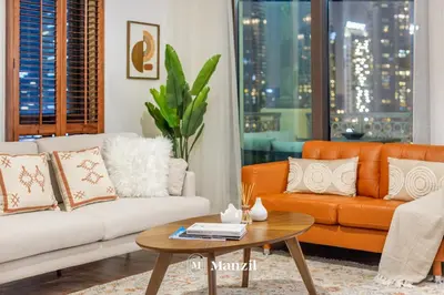 a living room with two couches and a coffee table at Manzil - Cozy 2BR Penthouse with Private Terrace and Full Burj View in Downtown in Dubai
