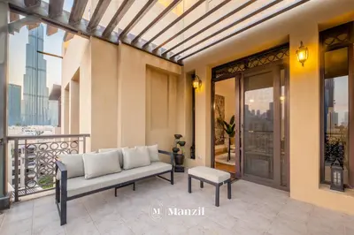 a living room with a couch on a balcony at Manzil - Cozy 2BR Penthouse with Private Terrace and Full Burj View in Downtown in Dubai