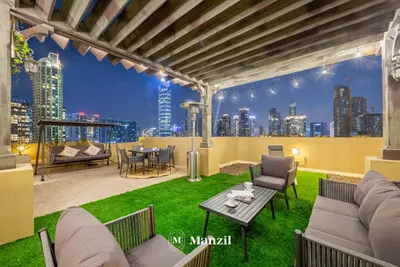 a rooftop patio with a view of a city skyline at Manzil - Cozy 2BR Penthouse with Private Terrace and Full Burj View in Downtown in Dubai