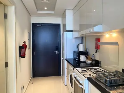 a kitchen with a black door and a stove at Lux BnB Studio Ghalia JVC in Dubai
