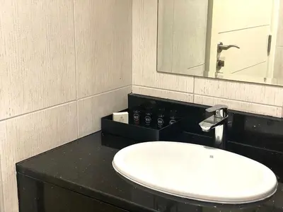 a bathroom with a white sink and a mirror at Lux BnB Studio Ghalia JVC in Dubai