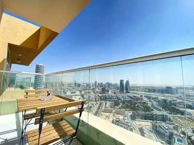 a balcony with a wooden bench and a view of the city at Lux BnB Studio Ghalia JVC in Dubai