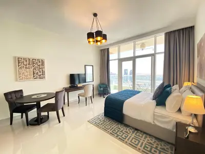 a bedroom with a bed and a desk and a table at Lux BnB Studio Ghalia JVC in Dubai