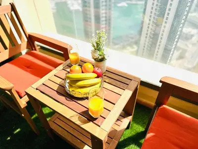 a table with a bowl of fruit and two glasses of orange juice at Luxury Casa - Indigo Sea View Apartment JBR Beach 2BR in Dubai