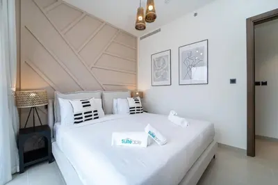 a white bedroom with a large white bed with pillows at Intimate Apartment with Scenic View of Dubai Creek in Dubai