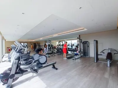 a gym with several treadmills and people in it at Intimate Apartment with Scenic View of Dubai Creek in Dubai