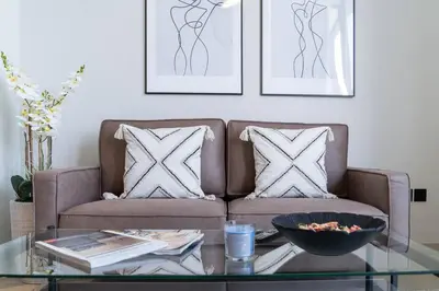 a living room with a couch and a glass table at Intimate Apartment with Scenic View of Dubai Creek in Dubai