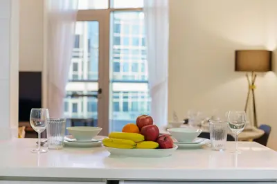 a table with a bowl of fruit and wine glasses at Impressive View 2BR in Dubai Marina Walk2Beach in Dubai