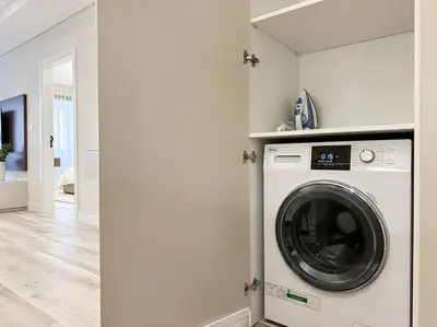 a washer and dryer in a white laundry room at Upgraded Gorgeous 1BR at 5 Star Resort in Dubai