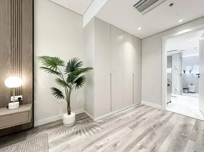 a white room with a palm tree in it at Upgraded Gorgeous 1BR at 5 Star Resort in Dubai