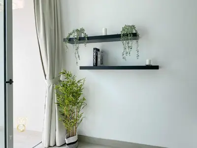 a room with two shelves with plants and a window at Stylish Studio Apartment in JVC with Contemporary in Dubai