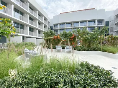 a garden with two chairs in front of a building at Stylish Studio Apartment in JVC with Contemporary in Dubai
