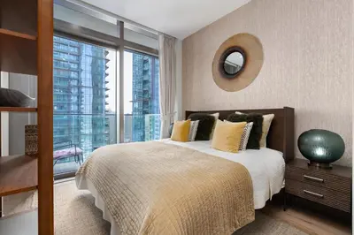 a bedroom with a bed and a large window at Vacay Lettings - Suite room in Marina gate, Jumeirah living in Dubai