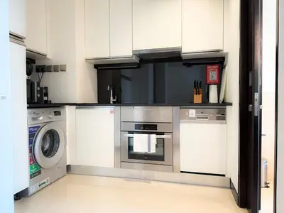 a kitchen with a stove and a washer and dryer at Scenic view studio/Dubai Marina in Dubai