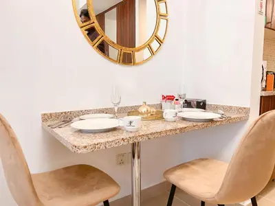 a dressing table with two chairs and a mirror at Cosmos Living Cozy Studio Near Dubai Marina in Dubai