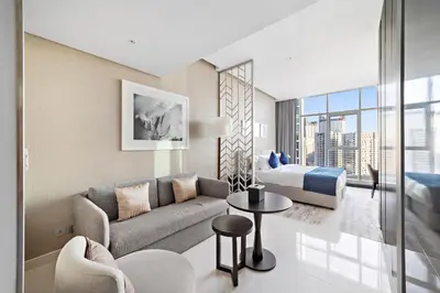 a living room with a couch and a bed at ALiving Modern Studio I Canal View I DAMAC Maison Prive A- 1102 in Dubai