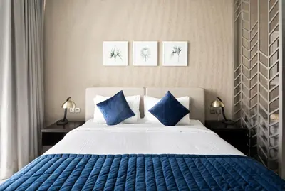 a bedroom with a large bed with blue pillows at ALiving Modern Studio I Canal View I DAMAC Maison Prive A- 1102 in Dubai