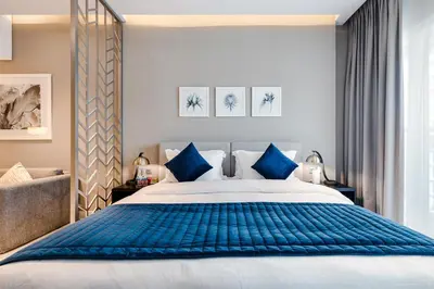 a bedroom with a large bed with blue pillows at ALiving Cozy & Modern Studio I DAMAC Maison Prive, Business Bay -302 in Dubai