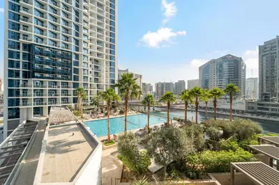 a view of a pool with palm trees and buildings at ALiving Cozy & Modern Studio I DAMAC Maison Prive, Business Bay -302 in Dubai