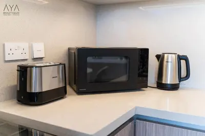 a microwave sitting on a counter next to a coffee maker at Elegant Luxury Apartment with Stunning Lake Views in Dubai Creek Harbour By ĀYA Boutique in Dubai