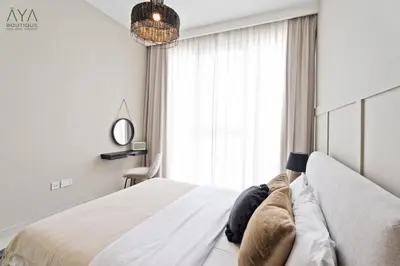 a bedroom with a white bed with a large window at Elegant Luxury Apartment with Stunning Lake Views in Dubai Creek Harbour By ĀYA Boutique in Dubai