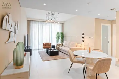 a living room with a table and a couch at Elegant Luxury Apartment with Stunning Lake Views in Dubai Creek Harbour By ĀYA Boutique in Dubai