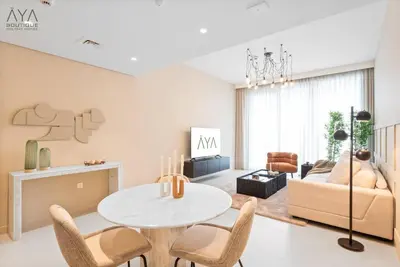 a living room with a table and chairs and a couch at Elegant Luxury Apartment with Stunning Lake Views in Dubai Creek Harbour By ĀYA Boutique in Dubai