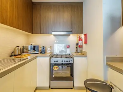 a small kitchen with a stove and a microwave at Bright and Splendid 1BR with Marina View in Dubai