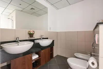 a bathroom with two sinks and a toilet at Frank Porter - The Jwls T2 in Dubai