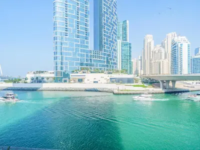 two boats in the water in a city with tall buildings at Marvelous 1BR with Beautiful Marina View in Dubai