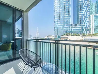a balcony with a chair and a view of the water at Marvelous 1BR with Beautiful Marina View in Dubai