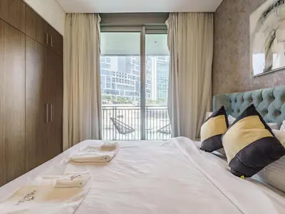 a bedroom with a large white bed with a balcony at Marvelous 1BR with Beautiful Marina View in Dubai