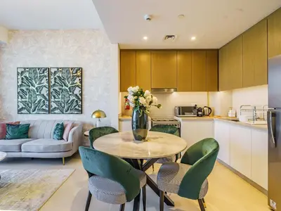 a kitchen and living room with a table and chairs at Gorgeous 1 BR with Private Terrace - Marina View in Dubai