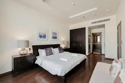 a bedroom with a large white bed and wooden floors at 2 BD Tiara Palm Views, Beach & Pool, Amazing views of the Palm in Dubai