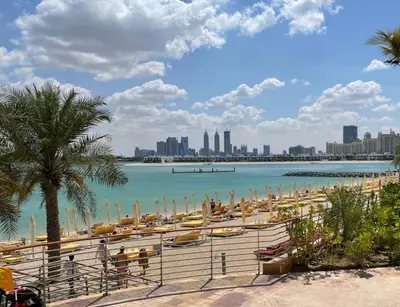 a beach with umbrellas and boats in the water at 2 BD Tiara Palm Views, Beach & Pool, Amazing views of the Palm in Dubai