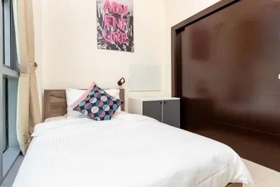 a bedroom with a large bed with a large headboard at Captivating Arabian Sea & Burj Khalifa Views in Dubai