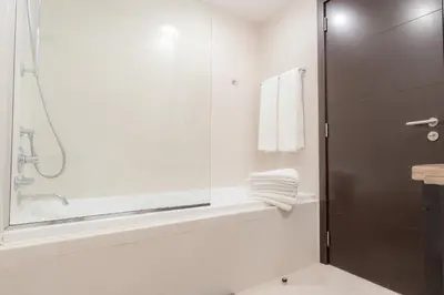 a bathroom with a shower and a tub and a sink at Captivating Arabian Sea & Burj Khalifa Views in Dubai