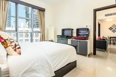 a hotel room with a bed with two suitcases at Captivating Arabian Sea & Burj Khalifa Views in Dubai