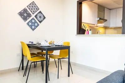 a dining room with a black table and yellow chairs at Captivating Arabian Sea & Burj Khalifa Views in Dubai