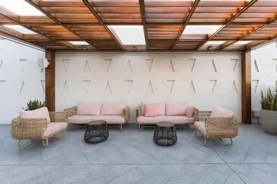 a group of wicker chairs and tables in front of a wall at Palm Tower St. Regis Amazing view high-end Studio in Dubai