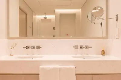 a bathroom with two sinks and a large mirror at Palm Tower St. Regis Amazing view high-end Studio in Dubai