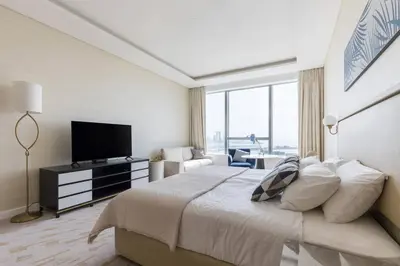 a bedroom with a large bed and a television at Palm Tower St. Regis Amazing view high-end Studio in Dubai