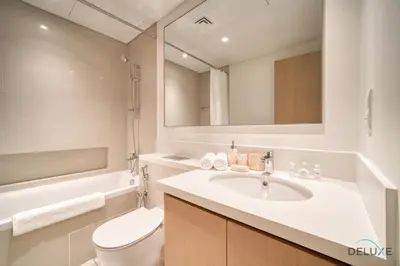 a bathroom with a sink and a toilet and a mirror at Elegant 1BR at Harbour Views Tower 1 by Deluxe Holiday Homes in Dubai