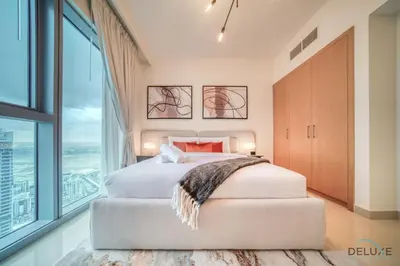a bedroom with a large bed and a large window at Alluring 1BR at Harbour Views Tower 1 by Deluxe Holiday Homes in Dubai