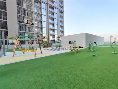 a playground in the middle of a building with green grass at Perfect 1 BR for Family Stay - Close to Downtown in Dubai
