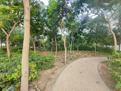 a walkway in a park with trees and flowers at Perfect 1 BR for Family Stay - Close to Downtown in Dubai