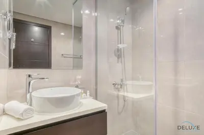 a bathroom with a sink and a glass shower at Soothing 1BR at Merano Business Bay by Deluxe Holiday Homes in Dubai