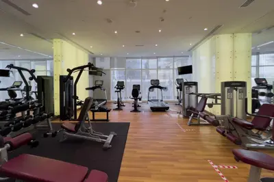 a gym with treadmills and elliptical machines at GuestReady - Sweet Paradise near Marina Walk in Dubai