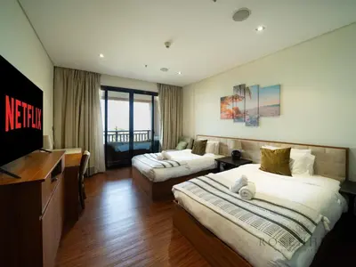 a hotel room with two beds and a flat screen tv at Luxury Anantara Res - Sea & Burj AlArab View in Dubai